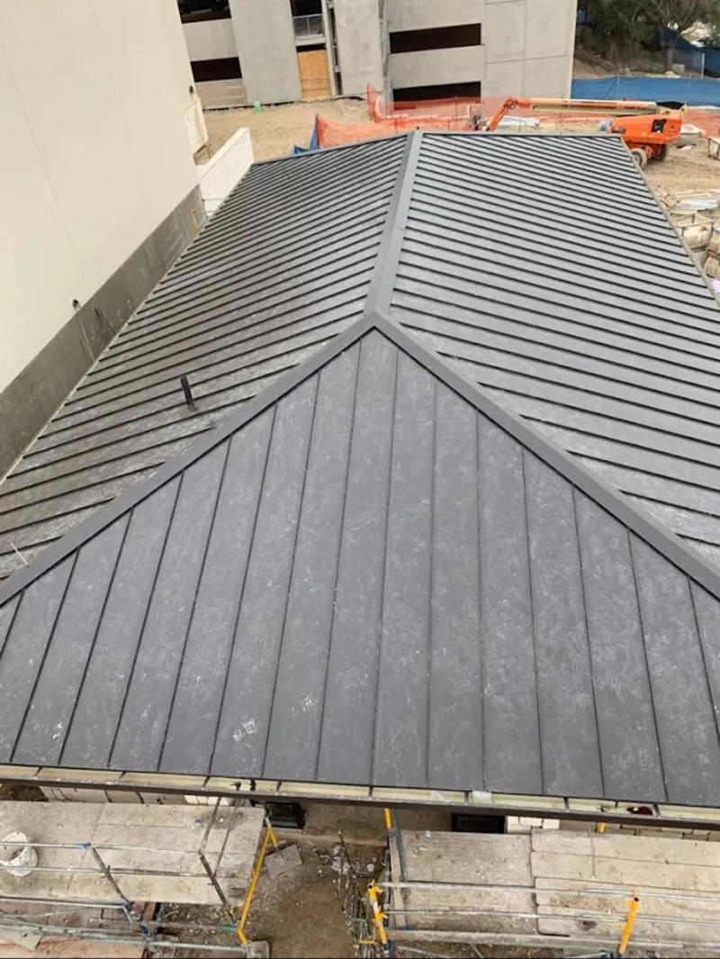 Commercial metal roof construction with crane equipment in Cooper City